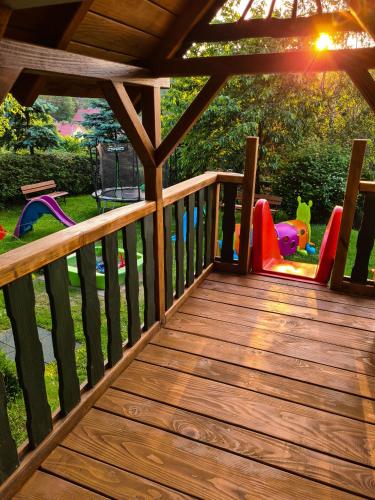 a wooden deck with two chairs and a table at Domki Pod Horbem in Polańczyk