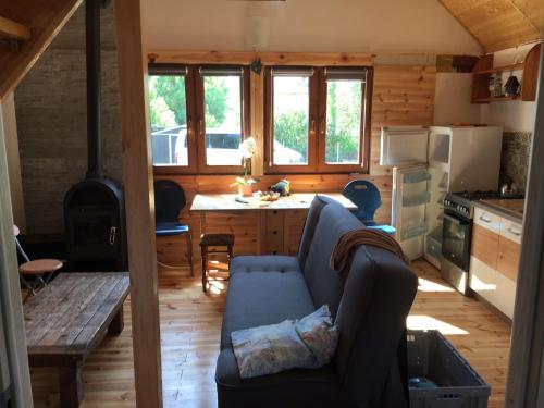 a living room with a couch and a kitchen at Domek na Skarpie in Sztutowo