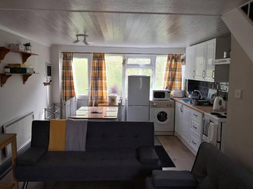 a living room with a couch and a kitchen at 'Le Chalet II' free unlimited wifi 2 bed chalet House in Pembrokeshire