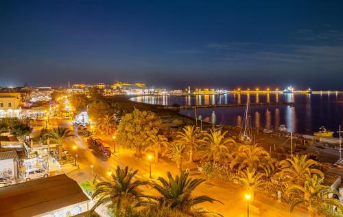 a view of a city at night with a harbor at SAVUS Boutique Hotel in Rethymno Town