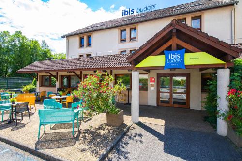 a restaurant with tables and chairs in front of a building at ibis budget Grenoble Voreppe in Voreppe