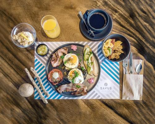 a table with a plate of breakfast food and a cup of coffee at SAVUS Boutique Hotel in Rethymno Town