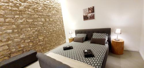 sypialnia z łóżkiem i kamienną ścianą w obiekcie Sam's Cottage Suite w mieście Niederweis