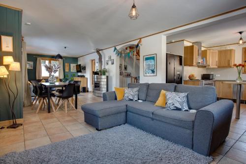 un salon avec un canapé bleu et une cuisine dans l'établissement Chamonix Large Chalet, Sleeps 12, 200m2, 5 Bedroom, 4 Bathroom, Garden, Jacuzzi, Sauna, à Chamonix-Mont-Blanc