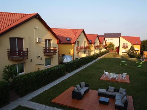 a row of houses with chairs and tables in a yard at Casa Ardeleneasca in Timişoara
