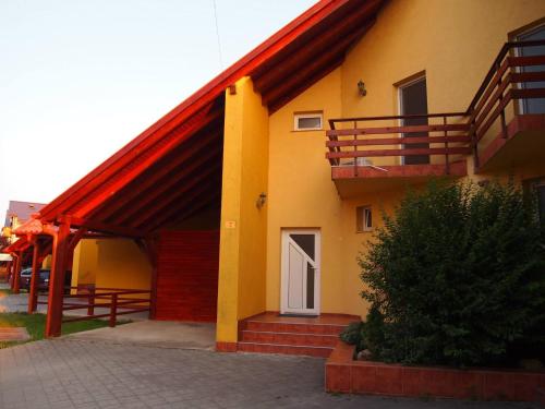 a yellow building with a white door and a balcony at Casa Ardeleneasca in Timişoara