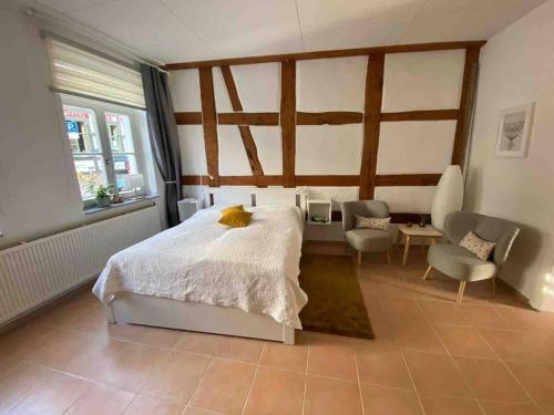 a bedroom with a large white bed and chairs at Ferienwohnung Lavendel in Waren