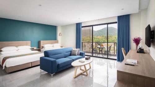 pokój hotelowy z łóżkiem i niebieską kanapą w obiekcie Vakara Hotel Kep w mieście Kep