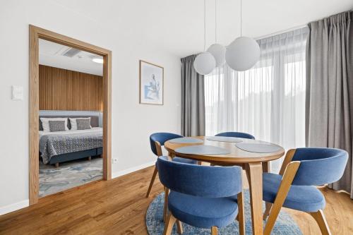 a dining room with a table and blue chairs at Maloves Resort & Spa in Władysławowo
