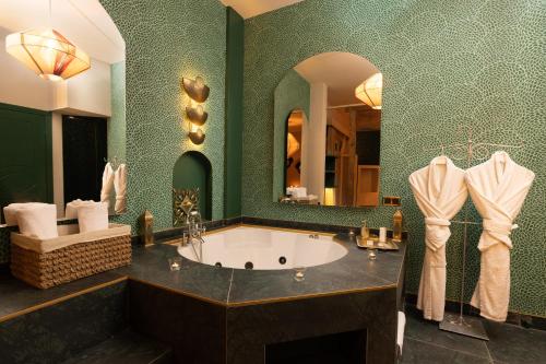 a bathroom with a tub and a green wall at La Capria Suite Hotel Alacati in Alacati