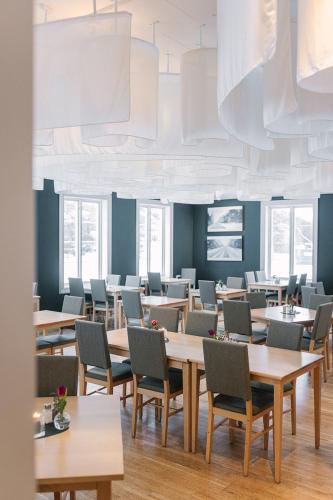a dining room with tables and chairs and windows at IceHotel in Jukkasjärvi