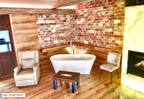a bathroom with a tub and a chair and a table at You and Me Apartments in Prosenická Lhota