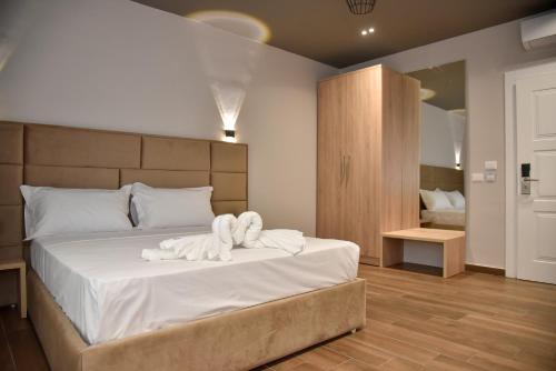 a bedroom with a bed with towels on it at Dolanit Hotels Lubjana in Durrës