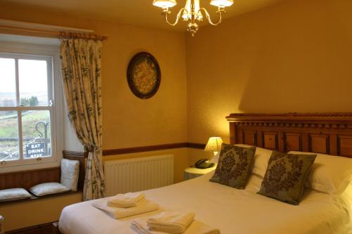 a bedroom with a bed with a window and a chandelier at The Charles Bathurst Inn in Richmond