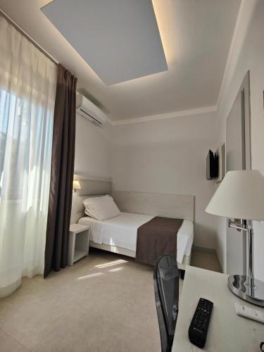 a bedroom with a bed and a desk with a computer at Park Hotel Giusy in Lido di Camaiore