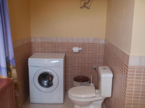 a bathroom with a washing machine and a toilet at Traditional House in Myrties