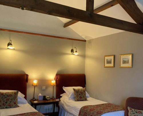 a room with two beds and two lights on the wall at The Charles Bathurst Inn in Richmond