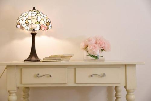 a table with a lamp and flowers on it at AFFITTACAMERE I PACIORRA in Favignana