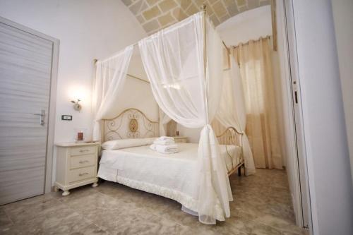 a bedroom with a white bed with a canopy at AFFITTACAMERE I PACIORRA in Favignana