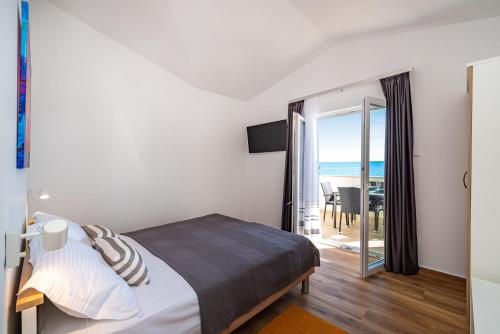 sypialnia z łóżkiem i widokiem na ocean w obiekcie la More Apartments w mieście Borovići
