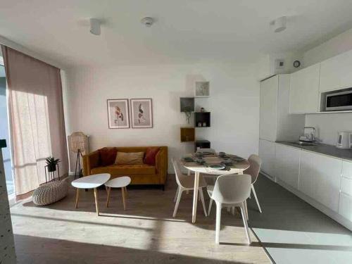 a kitchen and living room with a table and chairs at Modern Tower Apartament Gdynia in Gdynia