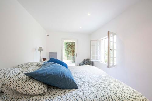 - une chambre blanche avec un lit et des oreillers bleus dans l'établissement Large Provencal villa with swimming pool in lush greenery LIVE IN CANNES, à Vallauris