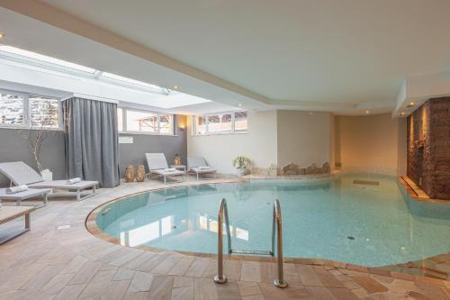 a large swimming pool in a hotel room at Hotel Nele in Ziano di Fiemme