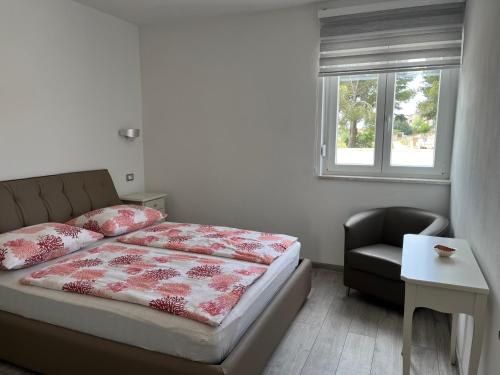 ein Schlafzimmer mit einem Bett, einem Stuhl und einem Fenster in der Unterkunft VILLA SILVIA - FUNTANA in Funtana
