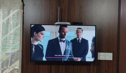 a flat screen tv with a group of people on it at Townside Lodge in Nuwara Eliya