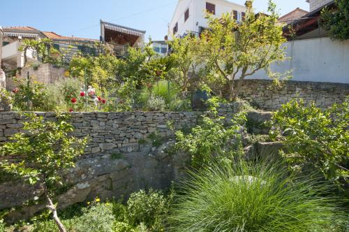 a garden with a stone wall and plants at Apartments Gorana in Splitska