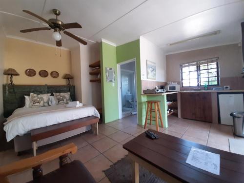 a bedroom with a bed and a table and a kitchen at Tourist Lodge Gansbaai in Gansbaai