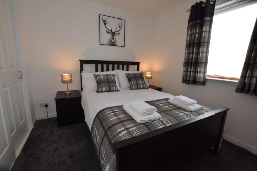 a bedroom with a bed with two towels on it at Silver Key Apartments III in Inverness