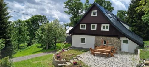 una casa con una mesa de picnic y un banco en Chalupa U Smrku en Horní Polubný