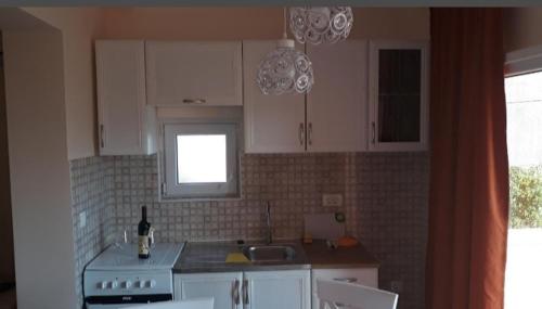 a kitchen with a stove and a sink and a window at Apartmani Tanja in Tivat