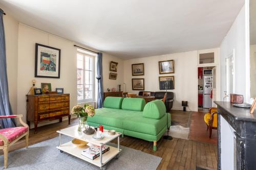 un salon avec un canapé vert et une table dans l'établissement Veeve - Picture Postcard, à Paris