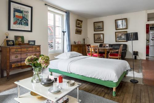 - une chambre avec un lit et une table fleurie dans l'établissement Veeve - Picture Postcard, à Paris