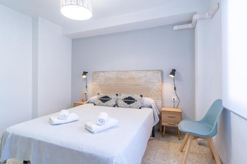 a bedroom with a bed and a blue chair at TrendyHomes El Puerto de Almería, próximo Playa y Centro,3 HAB, Espacioso, Familias, Wifi in Almería
