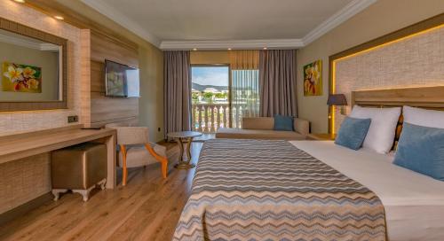 a hotel room with a bed and a desk at Samara Hotel Bodrum Ultra All Inclusive in Torba