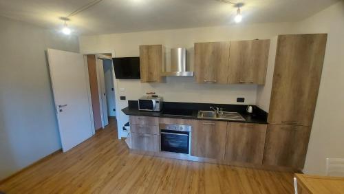 a kitchen with wooden cabinets and a wooden floor at Appartamenti il Bersaio Alloggio 2 in Sambuco