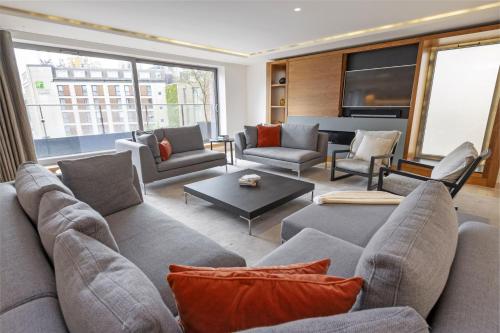 ein großes Wohnzimmer mit Sofas und einem Klavier in der Unterkunft Stayo Apartments Southbank in London