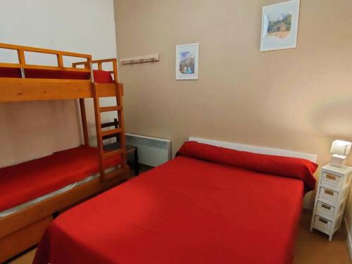 a bedroom with two bunk beds and a red bed at Appartement Cauterets, 2 pièces, 6 personnes - FR-1-234-231 in Cauterets