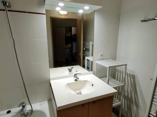 une salle de bain avec un lavabo et un miroir dans l'établissement Appartement T2bis à Cauterets, 6 pers, piscine, à 250m des télécabines, parking privé - FR-1-234-182, à Cauterets