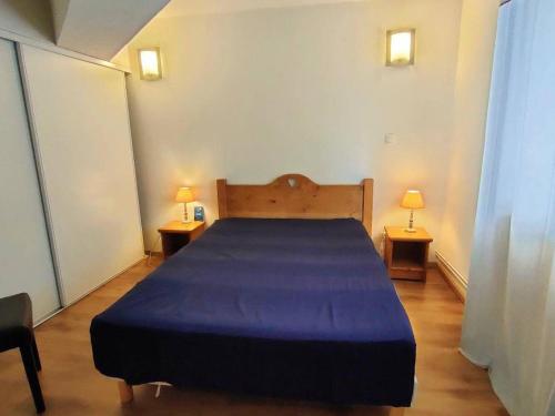 une chambre avec un grand lit avec une couverture bleue dans l'établissement Appartement T2bis à Cauterets, 6 pers, piscine, à 250m des télécabines, parking privé - FR-1-234-182, à Cauterets