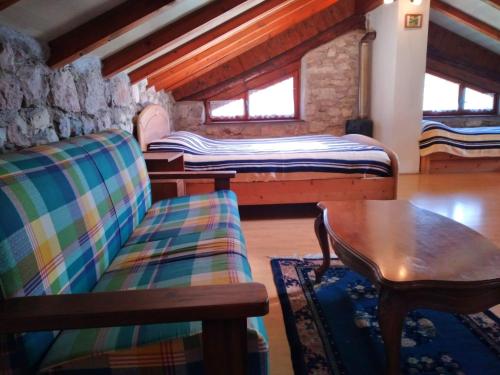 a room with two beds and a wooden table at Maso Mandrea in Arco