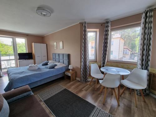 sypialnia z łóżkiem, stołem i krzesłami w obiekcie Willa Zachodni Brzeg w mieście Międzyzdroje