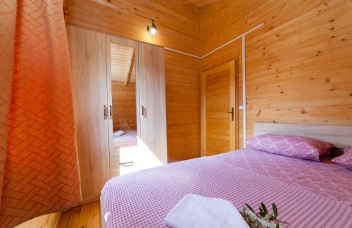 a bedroom with a bed in a wooden cabin at KATANA VILLAGE APARTMENT in Ulcinj