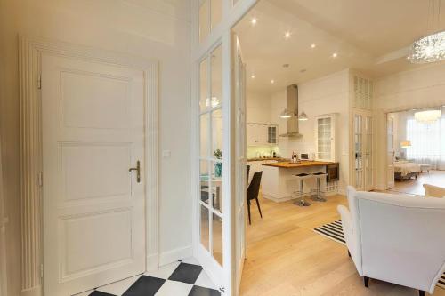 a living room with a white door and a kitchen at Romantic riverview Bestern in Szeged