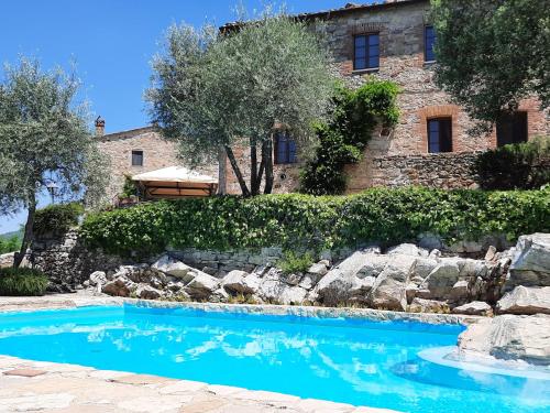 a swimming pool in front of a house at Borgo Livernano - Farmhouse with pool in Radda in Chianti