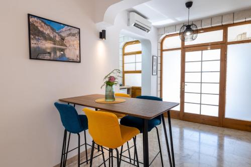 a dining room with a wooden table and blue chairs at Family apartments - Guesthouse Vranješ in Makarska