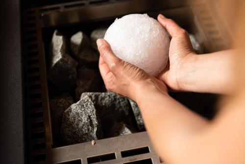 a person holding a rock in an oven at Hotel Nele in Ziano di Fiemme